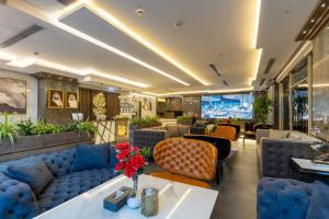 a lobby of a hotel with blue couches and tables at Gacine Hotel Tahlia فندق غسن التحلية in Al Madinah