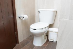 a white toilet in a bathroom with a roll of toilet paper at Marina Comodoro in Isla Mujeres +6 photos
