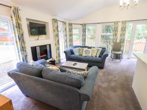a living room with two couches and a fireplace at Forest Pines Lodge in Bowness-on-Windermere
