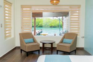 a bedroom with two chairs and a table and a window at Marina Comodoro in Isla Mujeres
