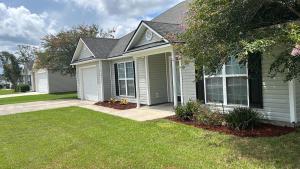a small white house with a grass yard at Spacious 3BR Home Sleeps 12 Near Valdosta in Hahira