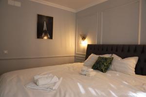 a bedroom with a white bed with towels on it at Casa Luna in Zalău