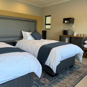 a hotel room with two beds and a microwave at Cozy NooK Mariental in Mariental