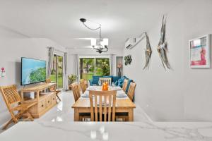 a dining room and living room with a table and chairs at Jardines del Mar 3 in Palm-Eagle Beach