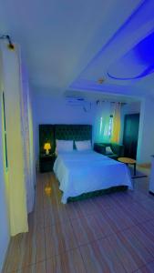 a bedroom with a white bed and a blue light at Abu Dhabi CC Hotel in Limbe