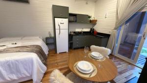 a bedroom with a bed and a table with plates on it at Vila Chamonix - Chalé Carmenere in Urubici