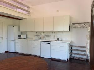 eine Küche mit weißen Schränken und weißen Geräten in der Unterkunft Brebu Holiday House in Brebu Mînăstirei + 41 Fotos