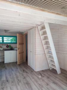 Habitación con pared de madera y escalera. en Węgiełek Treehouse Little Barn, en Kazimierz Dolny