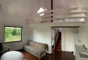 ein Wohnzimmer mit einem Sofa und einem Hochbett in der Unterkunft Brebu Holiday House in Brebu Mînăstirei