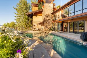 a swimming pool in front of a house at Crestwood 2309 Deluxe 1 Bedroom plus Loft in Snowmass Village