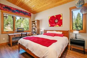 Un dormitorio con una cama y un escritorio y dos ventanas. en Luxury Ski Chalet - 684 Vasquez Road, en Winter Park