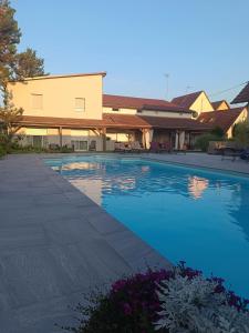 a large swimming pool in front of a building at La cabane au fond du jardin in Wittisheim