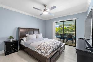 une chambre avec un lit et un ventilateur de plafond dans l'établissement Gorgeous Direct Sailboat Access home with solar heated pool - Villa Linda, à Cape Coral 20 autres photos