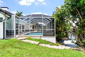 une maison en verre avec une piscine dans l'arrière-cour dans l'établissement Gorgeous Direct Sailboat Access home with solar heated pool - Villa Linda, à Cape Coral