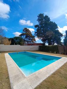 a blue swimming pool in a yard with trees at Hotel Paraiso in La Cumbre