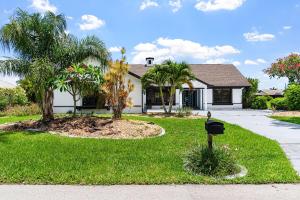 une maison avec une boîte aux lettres en face d'une cour dans l'établissement Gorgeous Direct Sailboat Access home with solar heated pool - Villa Linda, à Cape Coral