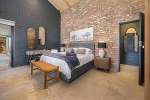 a bedroom with a bed and a brick wall at Avemore My Venue Le Verger in Onder-Papegaaiberg +50 photos