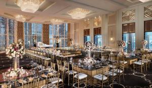 a banquet hall with tables and chairs and chandeliers at Four Seasons Hotel Abu Dhabi at Al Maryah Island in Abu Dhabi