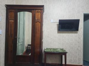 um quarto com uma porta, um espelho e uma televisão em Hotel Pueyrredón em Buenos Aires