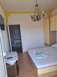 a small room with a bed and a chandelier at sukošan apartman 8 in Razvala