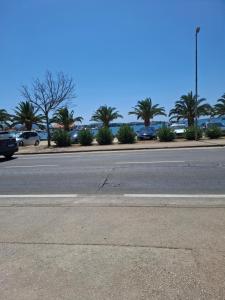 an empty street with cars parked on the side of the road at sukošan apartman 8 in Razvala