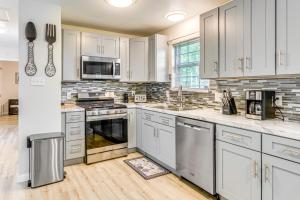 ノース・リトル・ロックにあるFish, Hike and Relax North Little Rock Gem with Yardの白いキャビネットとステンレス製の電化製品を備えたキッチン