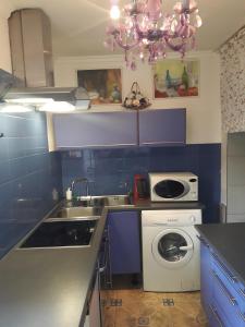 a kitchen with a sink and a washing machine at Apartment Magnolija in Jūrmala