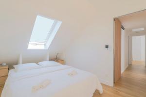 a white bed in a room with a window at L'Orangerie, Maison moderne avec jardin in Berck-sur-Mer