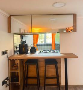a kitchen with a counter with two stools at a kitchen island at Orange House, City-Center Stay in Tbilisi City