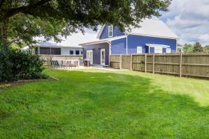 einen Hof mit einem blauen Haus und einem Zaun in der Unterkunft Cottage at Bella Vista in Foley