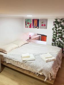 a bedroom with a large bed with towels on it at Orange House, City-Center Stay in Tbilisi City