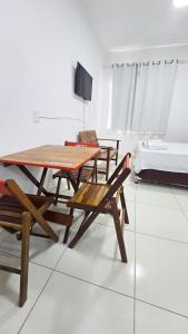 a table and chairs and a television in a room at Conforto a 200 m da Praia de Atalaia com ar in Atalaia Velha