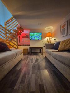 a living room with two couches and a tv at Orange House, City-Center Stay in Tbilisi City