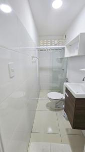 a white bathroom with a toilet and a sink at Conforto a 200 m da Praia de Atalaia com ar in Atalaia Velha +18 photos