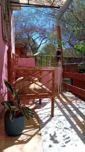 un portico con due panchine e una pianta in vaso di Entre Verdes alojamiento a Unquillo