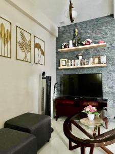 a living room with a tv and a coffee table at PATSY- 2BR at Camella Northpoint WIFI and NetFlix in Davao City +18 photos