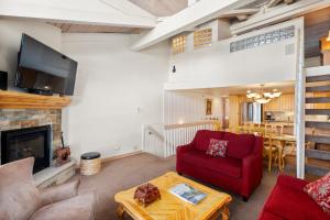 a living room with a red couch and a fireplace at Crestwood 3102 Standard 3 Bedroom Plus Loft in Snowmass Village