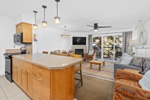スノーマス・ビレッジにあるCrestwood 3103 Deluxe 2 Bedroomのソファとテーブルのあるキッチンとリビングルーム