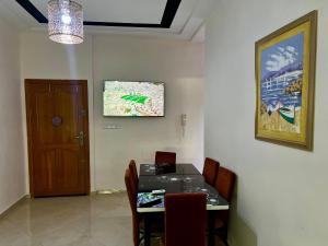 a dining room with a table and chairs and a door at Prestige Apartment - Fes Elegant Stay in Fès +17 photos