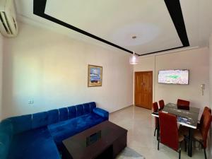 a living room with a blue couch and a table at Prestige Apartment - Fes Elegant Stay in Fès