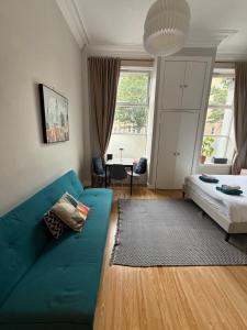 Una sala de estar con un sofá azul y una cama. en Charming studio flat in vibrant Leith, en Edimburgo