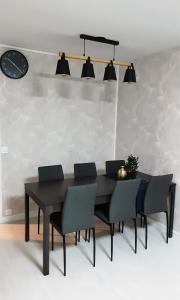 a dining room table with chairs and a clock on the wall at Room Urban Chic in Reims +4 photos