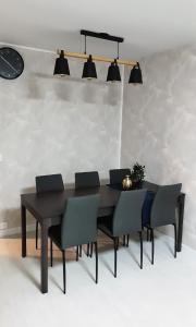 a black dining room table with chairs and a clock at Room Urban Chic in Reims