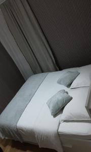a bed with white sheets and pillows in a room at Room Urban Chic in Reims