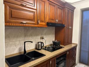 a kitchen with wooden cabinets and a sink at Garden - Apartment hotels in Tashkent