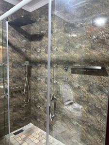 a bathroom with a shower with a glass door at Garden - Apartment hotels in Tashkent +35 photos