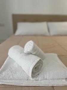 una pila de toallas blancas en una cama en R&S Apartment, en Monza