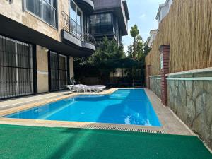 a small blue swimming pool next to a building at Home Mood Apart Hotel in Antalya