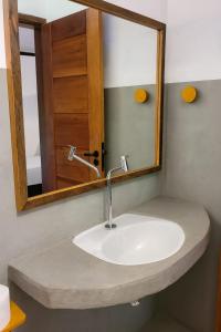 a sink in a bathroom with a mirror at Pousada Maria Dajuda Caraiva in Caraíva +18 photos
