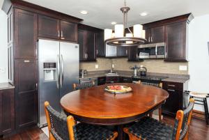 a kitchen with a wooden table and a refrigerator at Crestwood 3207 Premier 1 Bedroom in Snowmass Village